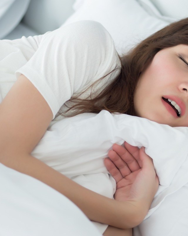 woman sleeping in bed with white sheets