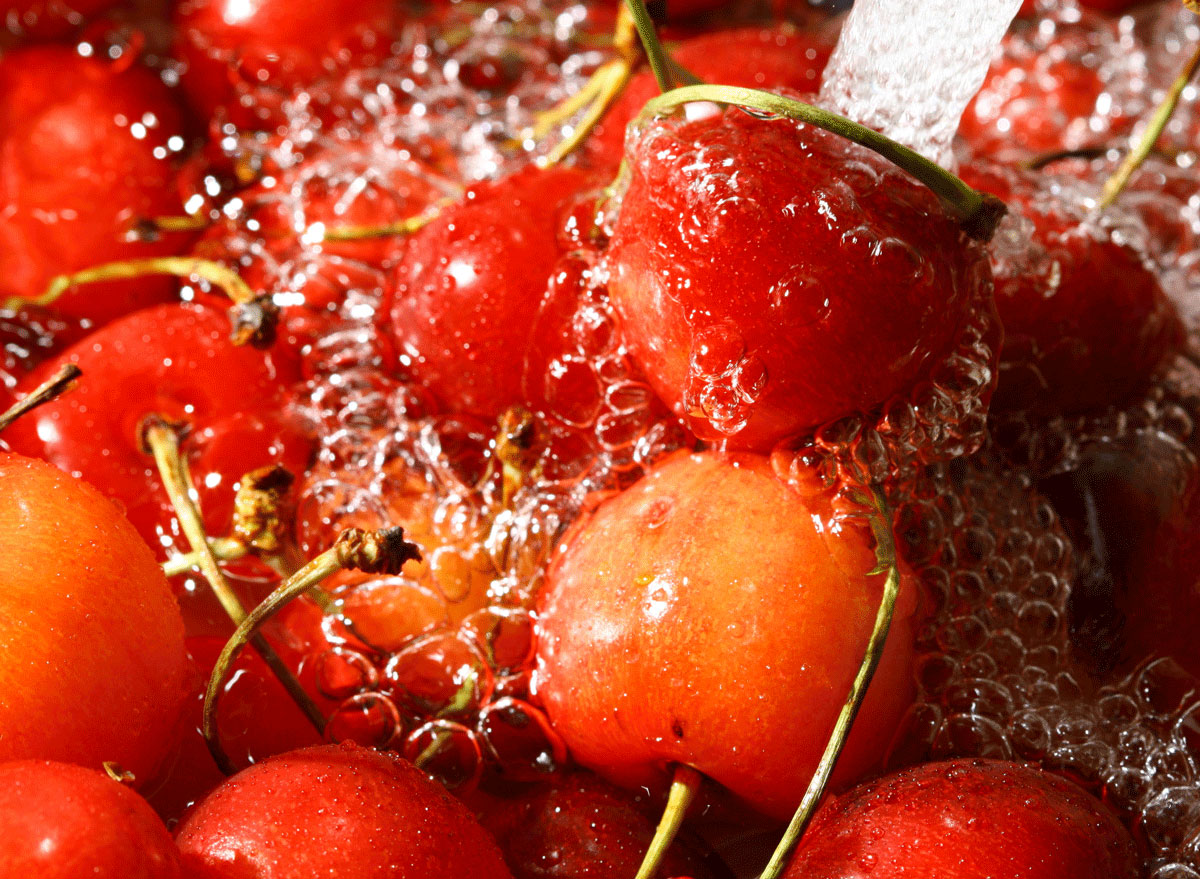 cherries being rinsed in a sink