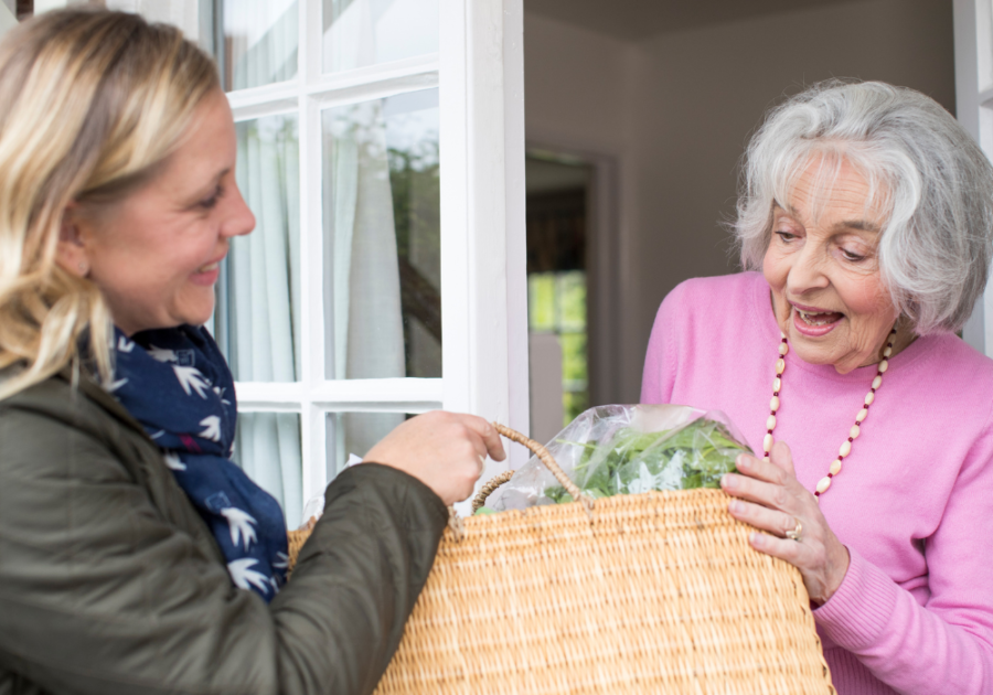 senior woman receiving a basket from daughter how to make someone happy