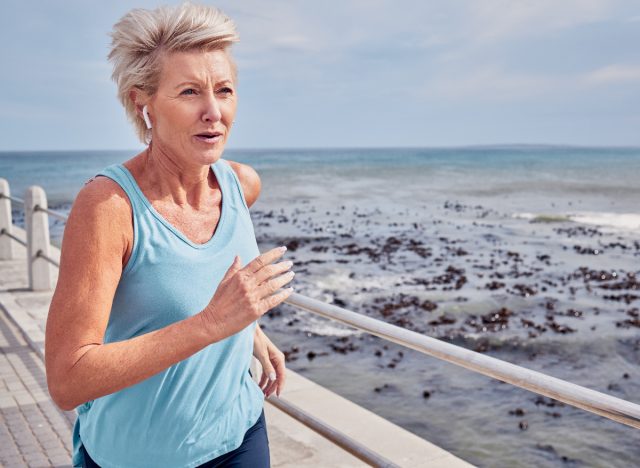mature woman running on boardwalk outdoors as part of anti-aging workout