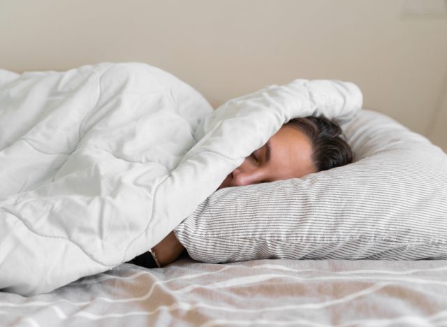 woman sleeping under blanket, layers