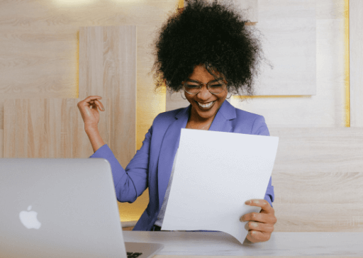 woman sitting at desk laughing traits of successful people