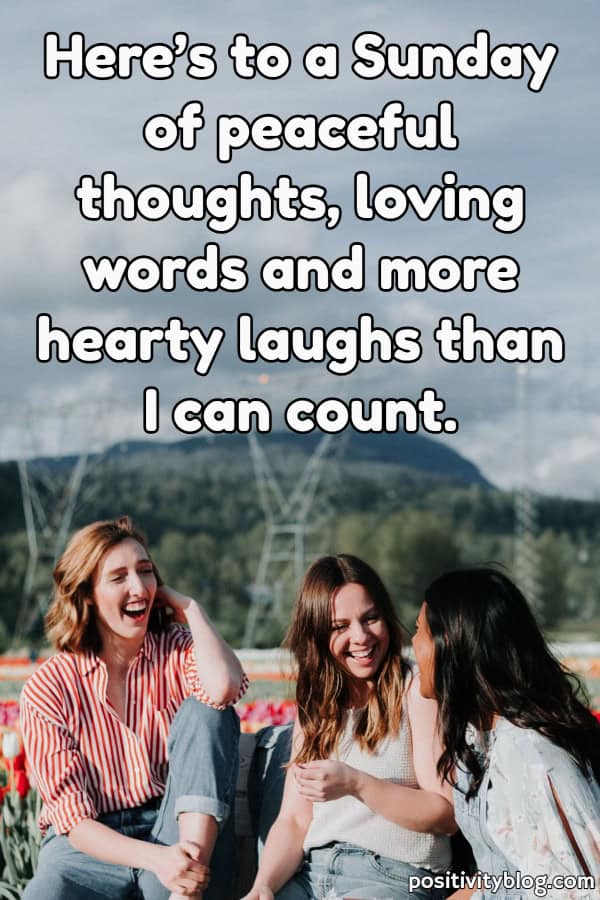 Three girls sitting outside and talking and laughing.