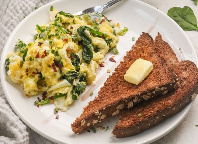 scrambled eggs and toast on a white plate