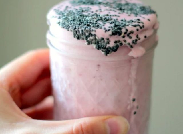 person holding a strawberry shake in a glass