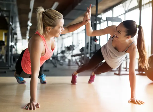 friends working out together in the gym and high fiving