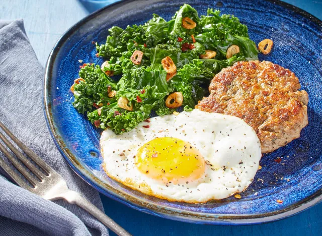 Keto frizzled eggs with fennel sausage on a blue plate