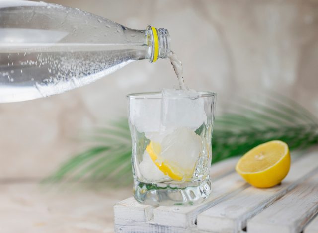 seltzer being poured into glass with lemon