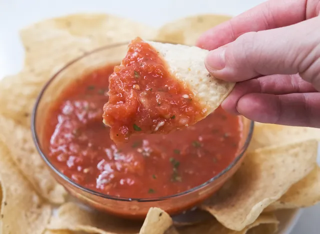 dipping into salsa with a tortilla chip