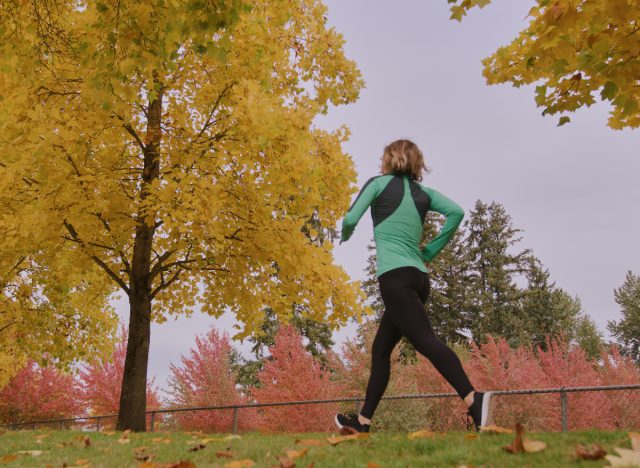 woman walking among fall foliage, demonstrating Centurion race walking