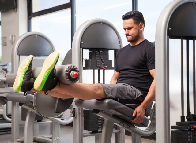 man doing leg extensions at the gym