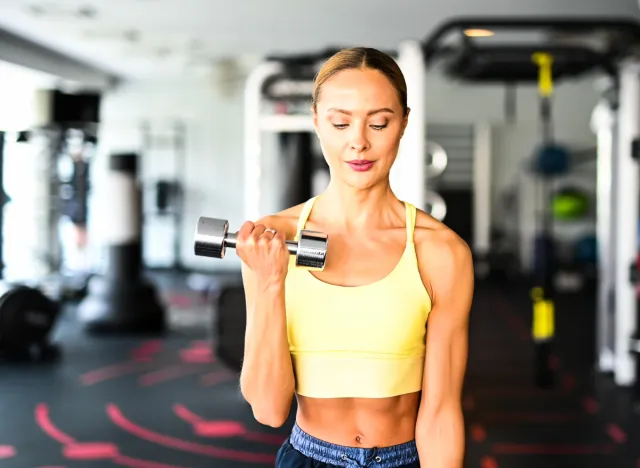 toned woman lifting weights, concept of the 4-1-1 workout method for fat loss