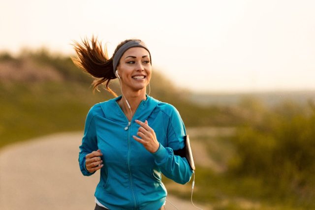 happy woman jogs along trail