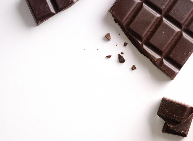 Broken chocolate bar isolated on white table. Horizontal composition. Top view